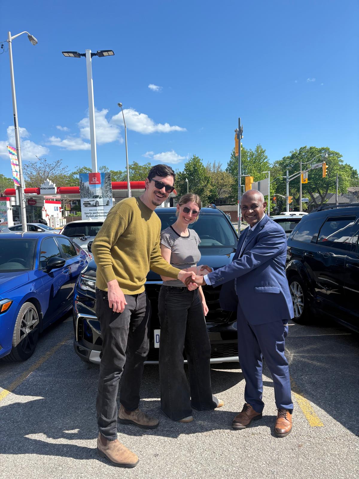 Ahmed Abdulrahman handing keys to happy customers - Ahmed Car Guy